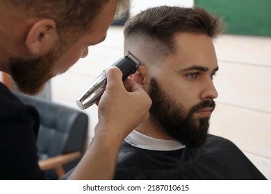 Professional hairdresser working with client in barbershop, closeup - Powered by Shutterstock