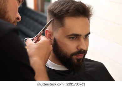 Professional hairdresser working with client in barbershop, closeup - Powered by Shutterstock