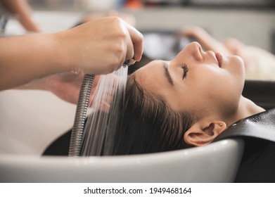 professional hairdresser working to water washing hair clean with woman client in beauty salon, coiffure, female head treatment with shampoo hair care, girl coiffure fashion concept
