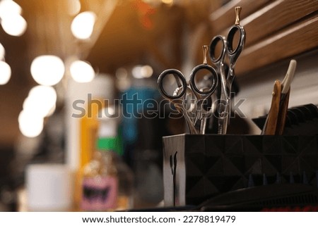 Professional hairdressing tools. Various steel scissors and combs, hairbrushes on wooden table on barbers workplace at barbershop salon. The concept of the hairdressing beauty industry. Copy space.