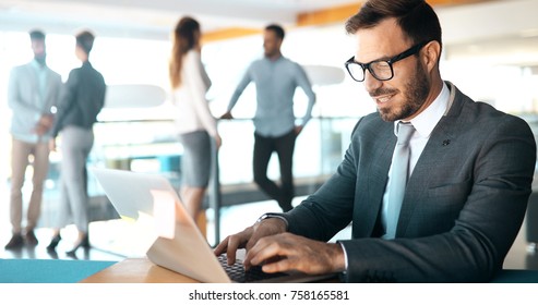 Professional handsome businessman using laptop at workplace - Shutterstock ID 758165581