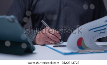 Professional hands-on approach data analysis, with charts and graphs organized on clipboard setting reflects focus and concentration in business environment