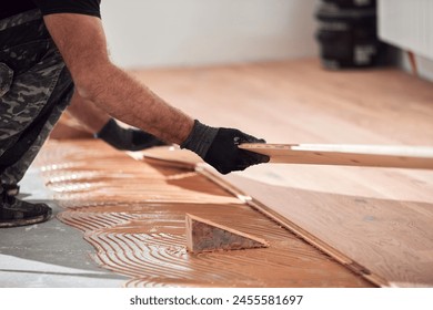 Professional handyman installing laminate flooring in a new apartment. - Powered by Shutterstock