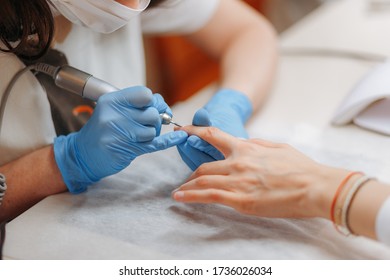 Professional hardware manicure using electric machines in a beauty salon. The master master uses an electric machine to remove nail polish hands during manicure - Shutterstock ID 1736026034