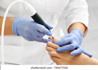 Professional hardware pedicure using electric machine.Patient on medical pedicure procedure, visiting podiatrist.Peeling feet with special electric device.Foot treatment in SPA salon.Podiatry clinic. - Shutterstock ID 749677318