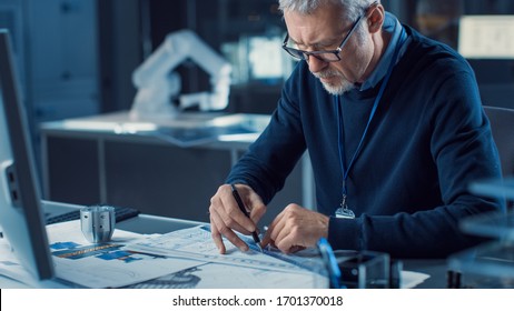 Professional Heavy Industry Engineer Draws Engine Concept Blueprint, References Computer. Engineering Bureau And Industrial Design Laboratory With Various Components In Sight