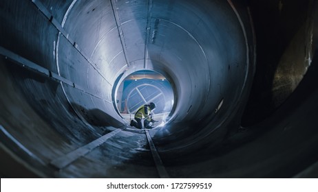 Professional Heavy Industry Worker Wearing Helmet Welding Inside Oil And Gas Pipe. Construction Of The Oil, Natural Gas And Fuels Transport Pipeline. Industrial Manufacturing Factory