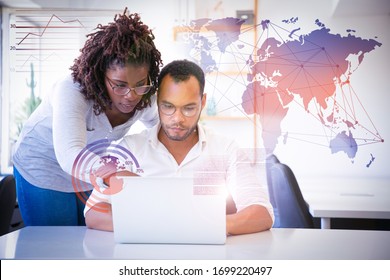 Professional Helping With Report And Virtual Statistic Graphics. Business Man And Woman In Casual Sitting And Standing At Workplace, Using Laptop, Pointing At Screen. Mentorship Concept