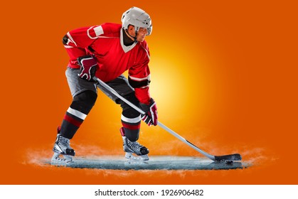 Professional hockey player skating on ice. Isolated on orange