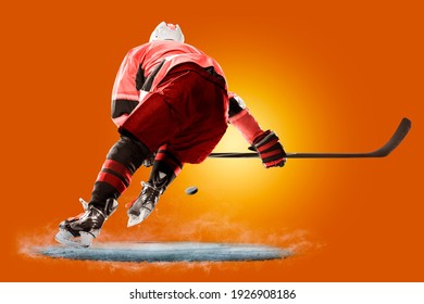 Professional Hockey Player Skating On Ice. Isolated On Orange