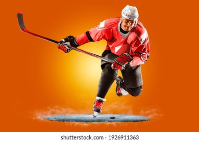 Professional Hockey Player Skating On Ice. Isolated On Orange