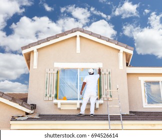 Professional House Painter Painting the Trim And Shutters of A Home.
