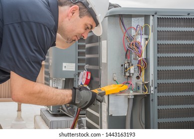 Professional hvac technician measuring amperage on an air conditioner unit
