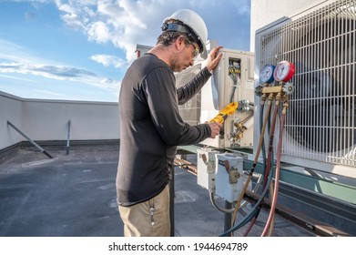 Professional HVAC technician taking an amperage reading on a mini-split ductless air conditioning system.