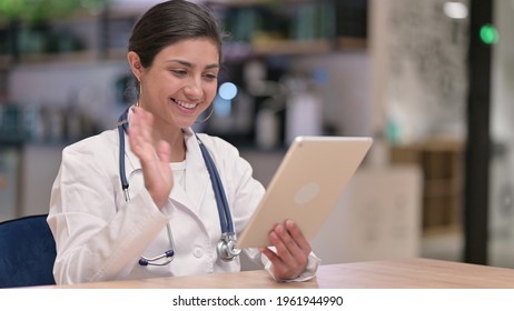 Professional Indian Female Doctor Doing Video Call On Tablet 