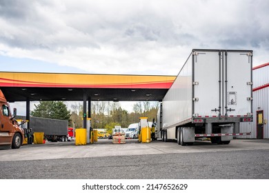 Professional Industrial Standard Big Rig Semi Trucks Tractors With Different Loaded Semi Trailers Refills The Semi Trucks Tanks With Diesel At Truck Stop Gas Station To Continue The Cargo Freights