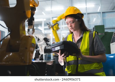 Professional and intelligence female engineer used her technical hard skill to fix, repair or maintenance machine robotic arm in factory or industrial, examining or welding automobile machine workshop - Powered by Shutterstock