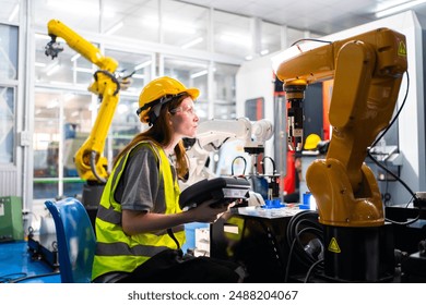 Professional and intelligence female engineer used her technical hard skill to fix, repair or maintenance machine robotic arm in factory or industrial, examining or welding automobile machine workshop - Powered by Shutterstock