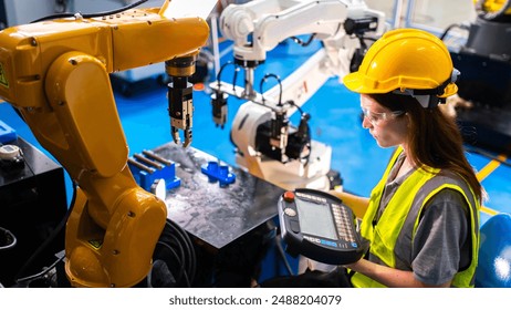 Professional and intelligence female engineer used her technical hard skill to fix, repair or maintenance machine robotic arm in factory or industrial, examining or welding automobile machine workshop - Powered by Shutterstock