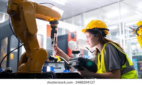Professional and intelligence female engineer used her technical hard skill to fix, repair or maintenance machine robotic arm in factory or industrial, examining or welding automobile machine workshop
