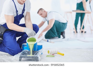 Professional Interior Construction Worker Pouring Green Color To Paint