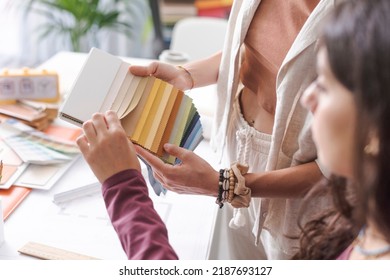 Professional interior designers working together on a project in their office: they are checking fabric swatches and picking the right color palette, hands close up - Powered by Shutterstock