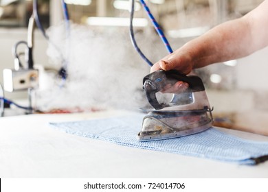 Professional Ironing In Dry Cleaner Detail Of Iron And Hands. Presser In Sewing Clothes Pressed