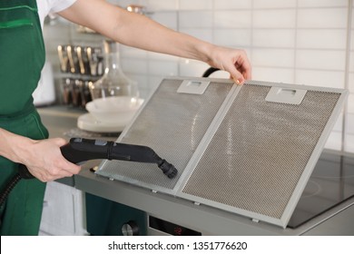 Professional Janitor Cleaning Mesh Filter Of Cooker Hood In Kitchen, Closeup