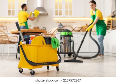 Professional Janitors Working In Kitchen, Focus On Bucket With Equipment