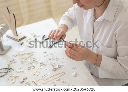 Professional jewelry designer making handmade jewelry in studio workshop close-up. Fashion, creativity and handmade concept