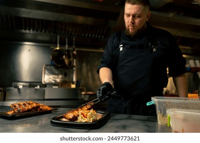 in a professional kitchen the chef puts ribs on a plate near the table and decorates them on a plate - Powered by Shutterstock