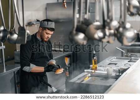 professional kitchen in the hotel restaurant chef puts burger buns on the grill