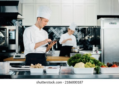 Professional kitchen of a restaurant, male chef checks the availability of products from an employee. Restaurant warehouse analytics. Preaplist checking - Powered by Shutterstock