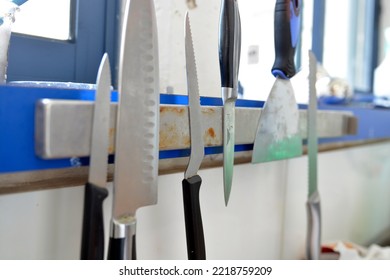 Professional Knives Hang On A Magnet In A Cafeteria Kitchen