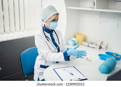 Professional laboratory investigations in healthcare system. Waist up portrait of lady doctor in medical uniform wearing gloves for making haemanalysis 庫存照片