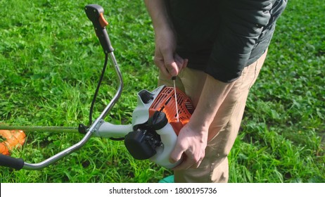 Professional lawn mower starts his new gas lawn trimmer