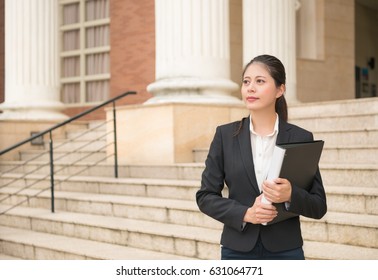 Professional Lawyer Business Woman Standing In Front Of Court And Holding Legal Documents Waiting For Customers Ready To Handle Case.