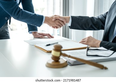 Professional lawyer shaking hands congratulation with a businessman after discussing a good deal of contract successful in the courtroom. - Shutterstock ID 2171981487