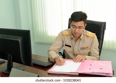 A Professional level Thai government officer, Civil servant signing the document on file.