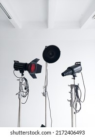 Professional lighting equipment, flashes, c-stands on a cyclorama in modern photo studio. Octabox, stripbox, softbox, buety plate and other stuff for photography.