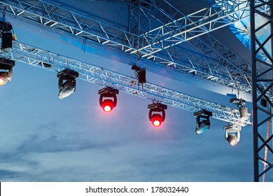Professional lighting equipment high above an outdoor concert