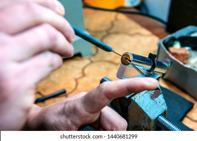 professional locksmith repairs the door lock cylinder