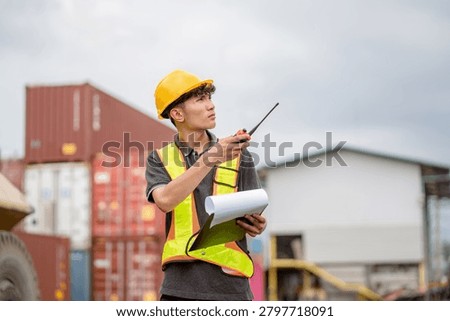 Professional logistics worker inspecting cargo containers at warehouse yard. Shipping, freight transport.