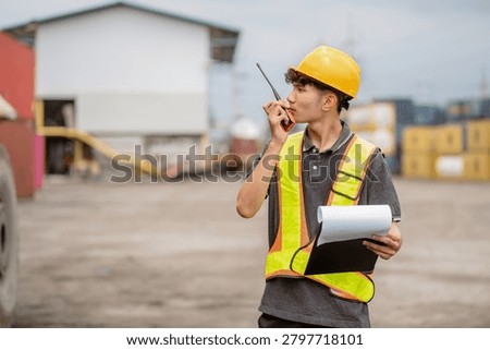 Professional logistics worker inspecting cargo containers at warehouse yard. Shipping, freight transport.