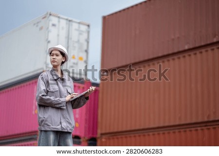 Professional logistics worker inspecting cargo containers at warehouse yard. Shipping, freight transport