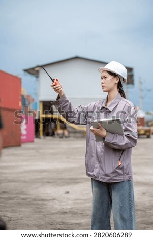 Professional logistics worker inspecting cargo containers at warehouse yard. Shipping, freight transport