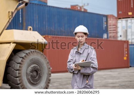 Professional logistics worker inspecting cargo containers at warehouse yard. Shipping, freight transport