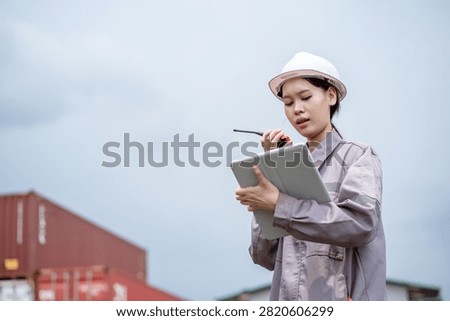Professional logistics worker inspecting cargo containers at warehouse yard. Shipping, freight transport