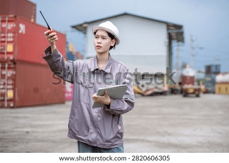 Professional logistics worker inspecting cargo containers at warehouse yard. Shipping, freight transport