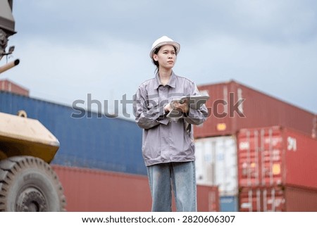 Professional logistics worker inspecting cargo containers at warehouse yard. Shipping, freight transport